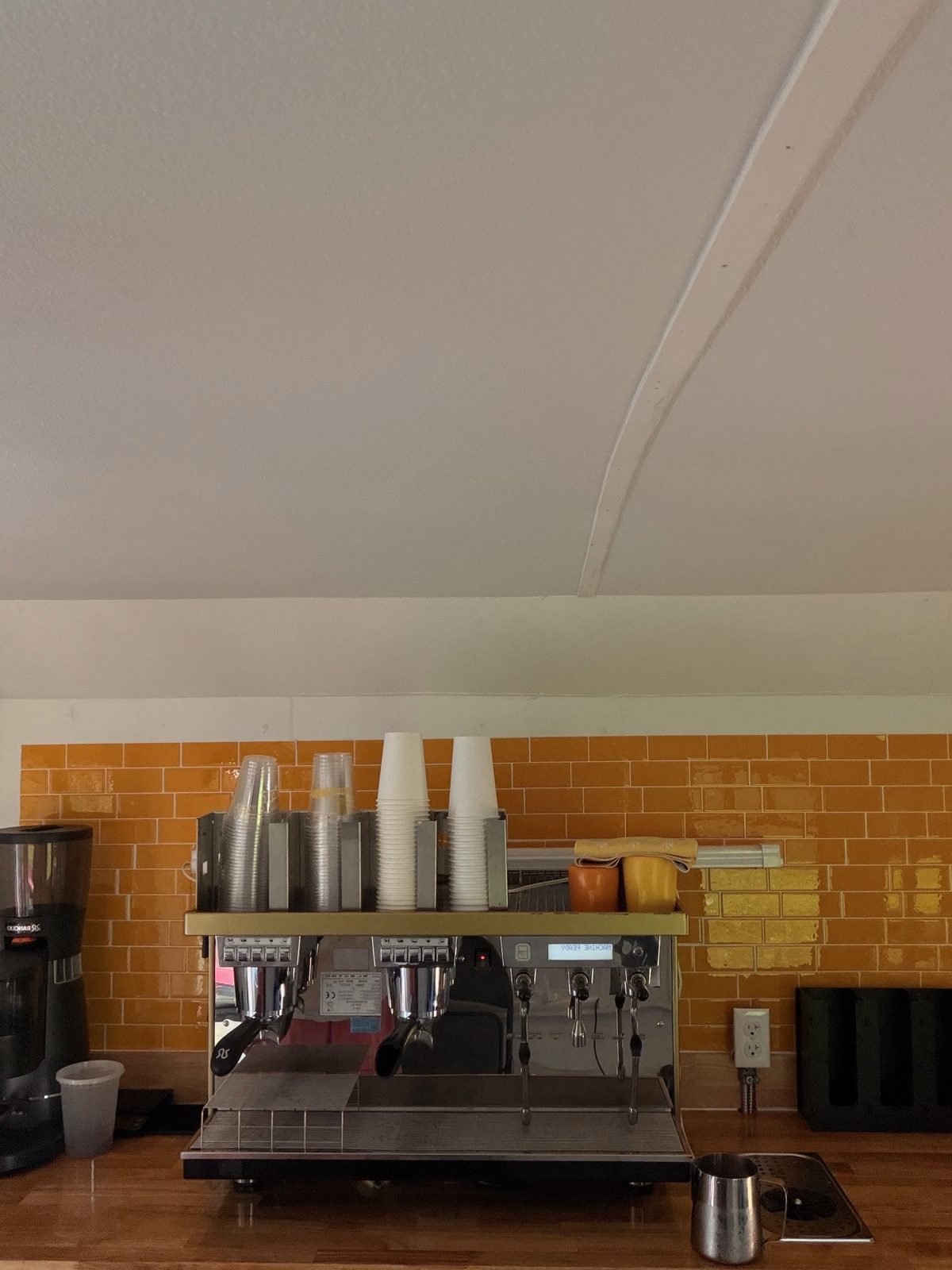 Inside the Maranatha Coffee Bus — retro orange tile and professional espresso machine