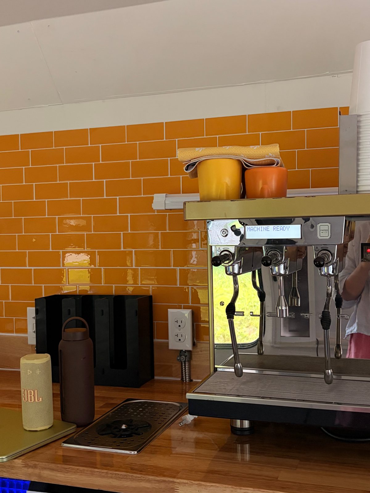 Espresso bar inside the Maranatha Coffee Bus with cups stacked and ready
